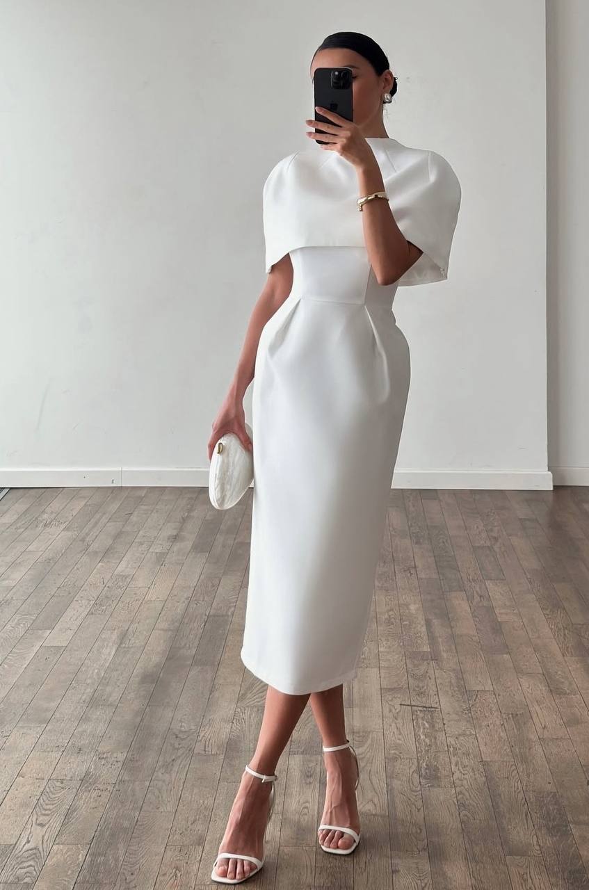 Woman wearing a white dress with a plain background