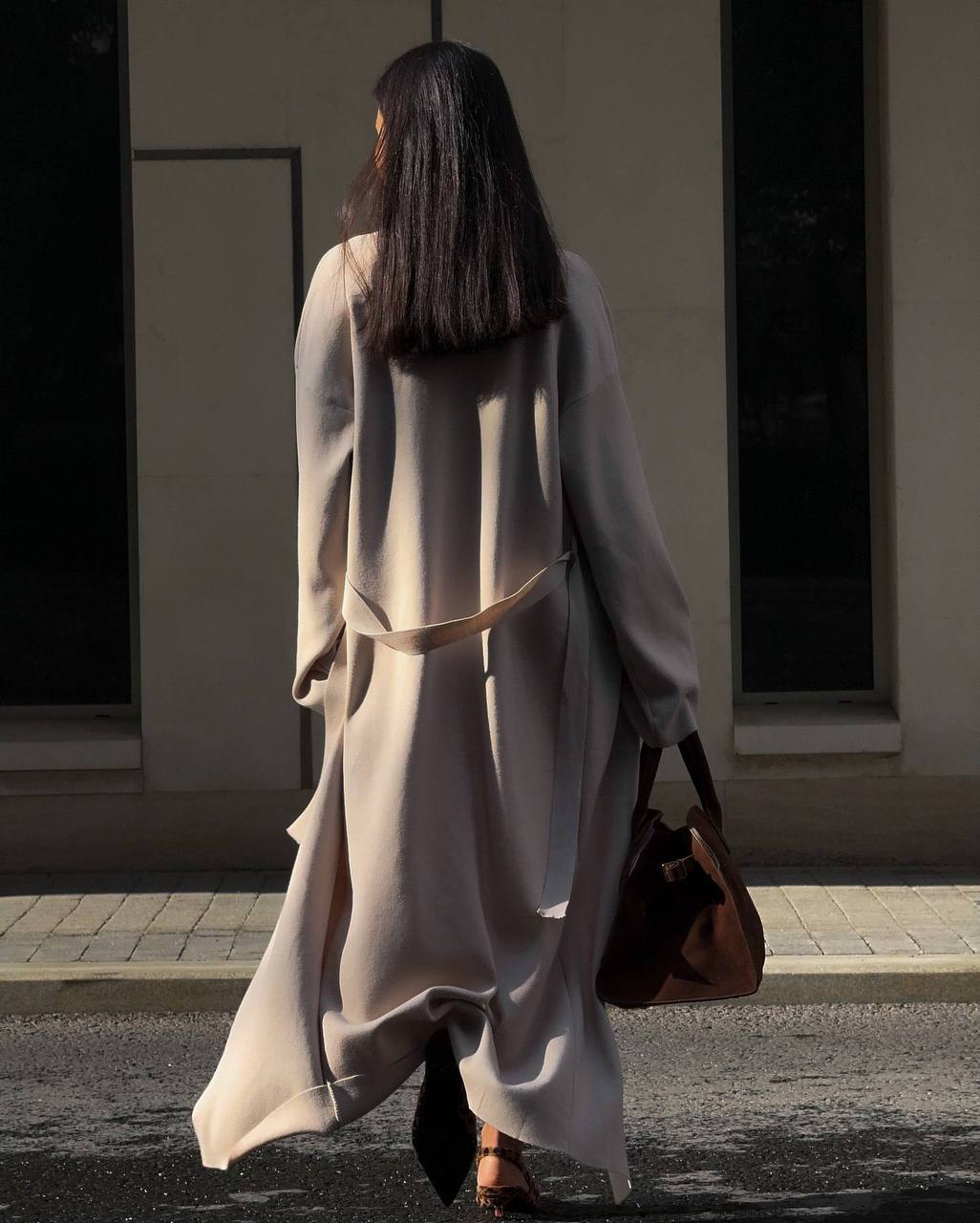 Woman in a long coat walking on a street