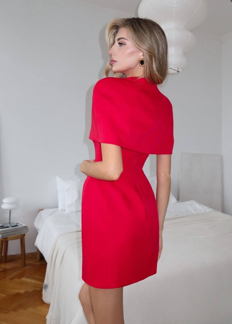 Woman in a red dress standing in a bedroom