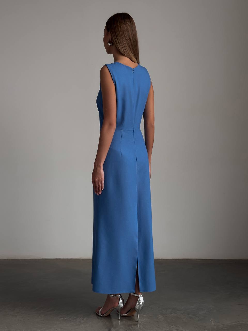 Woman wearing a blue dress with a plain background