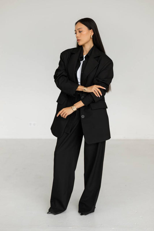 Woman wearing a black suit against a white background