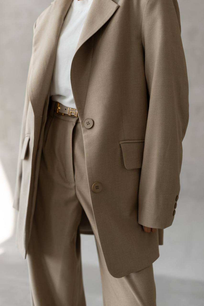 Beige suit worn by a person on a plain background