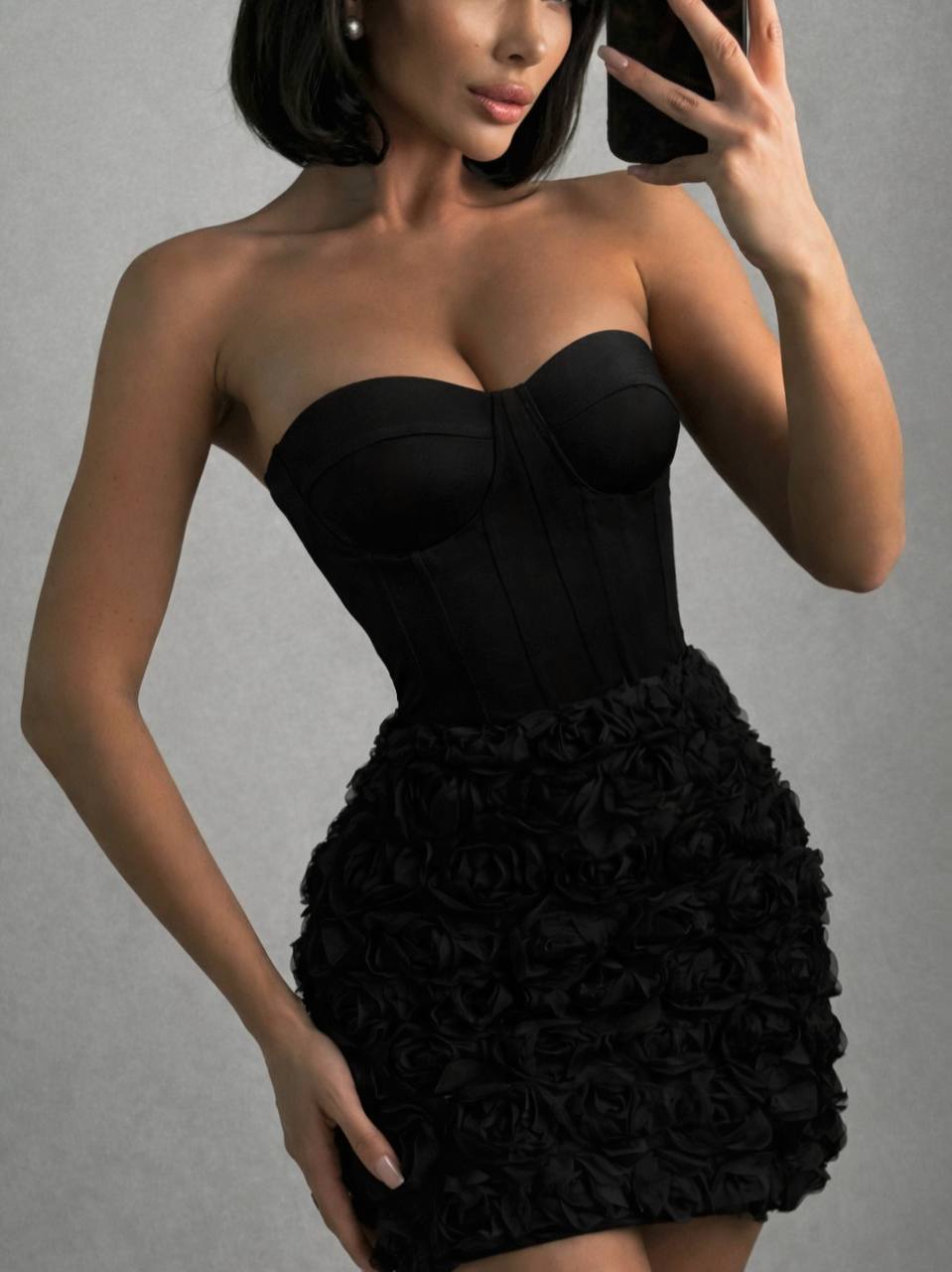 Black strapless dress with floral details on a gray background