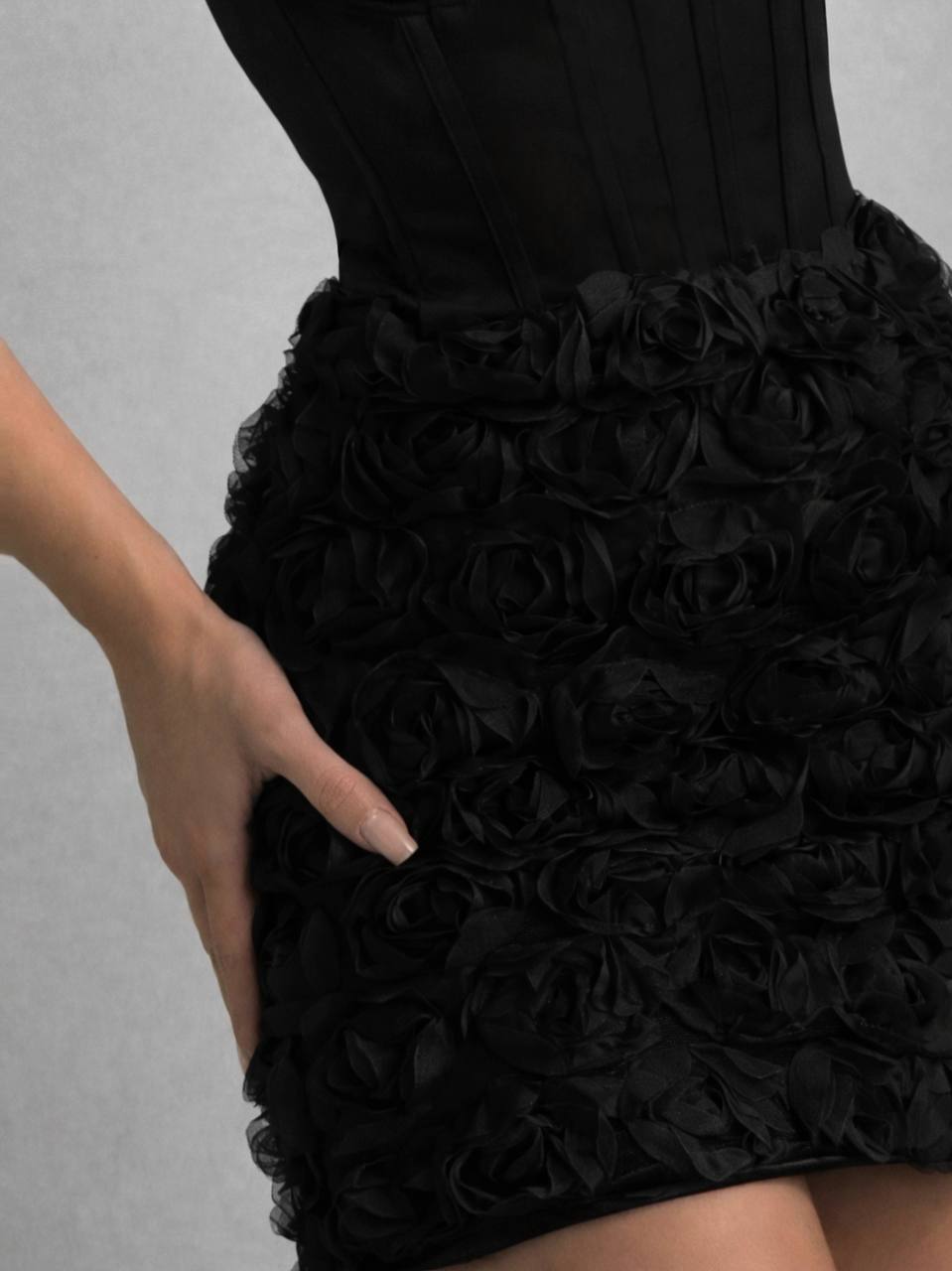 Black dress with floral details on a gray background