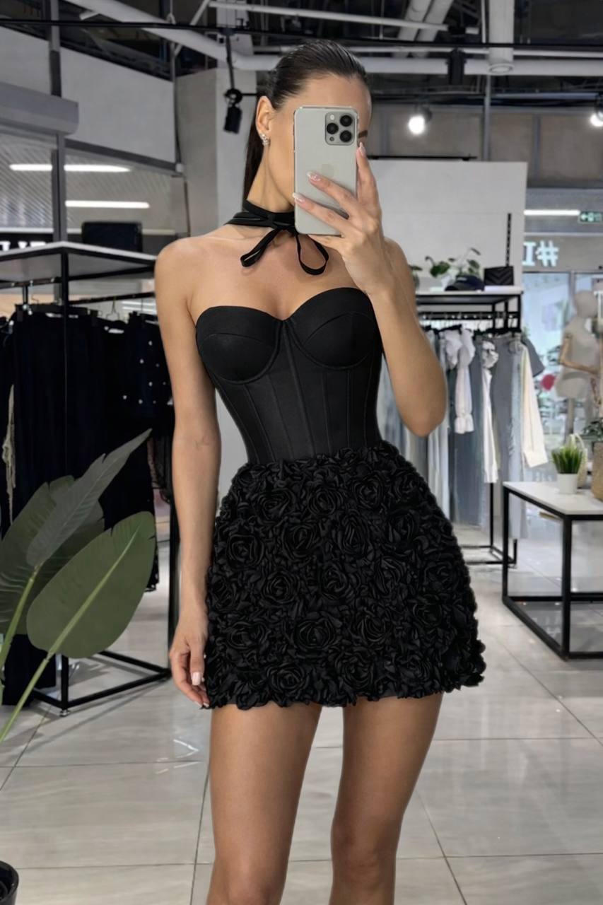 Person wearing a black dress with ruffled skirt in a store setting