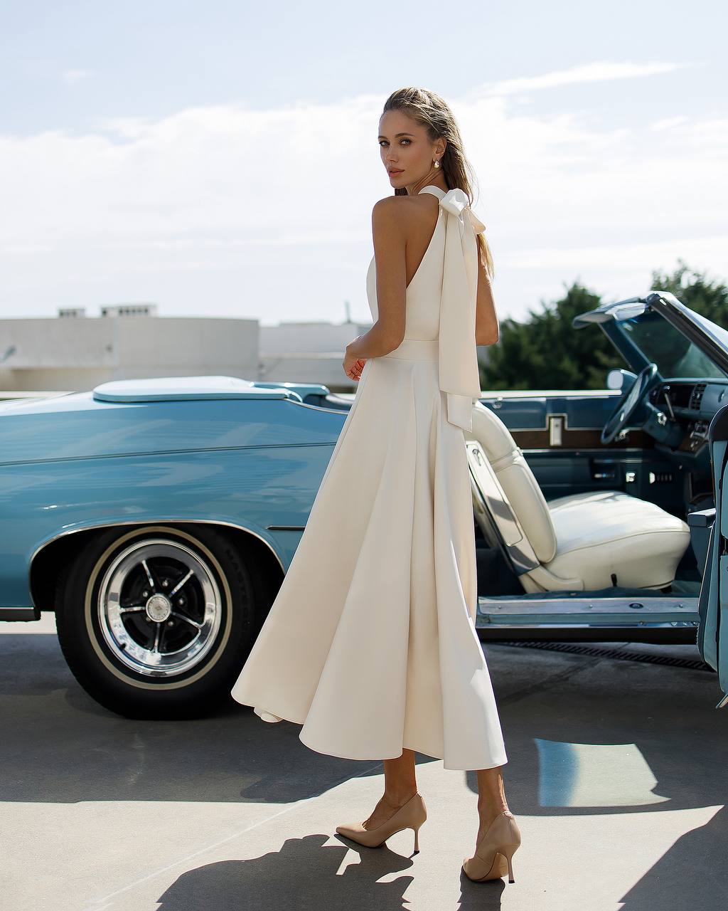 Woman in a white dress standing next to a classic blue car Wedding Guest dress