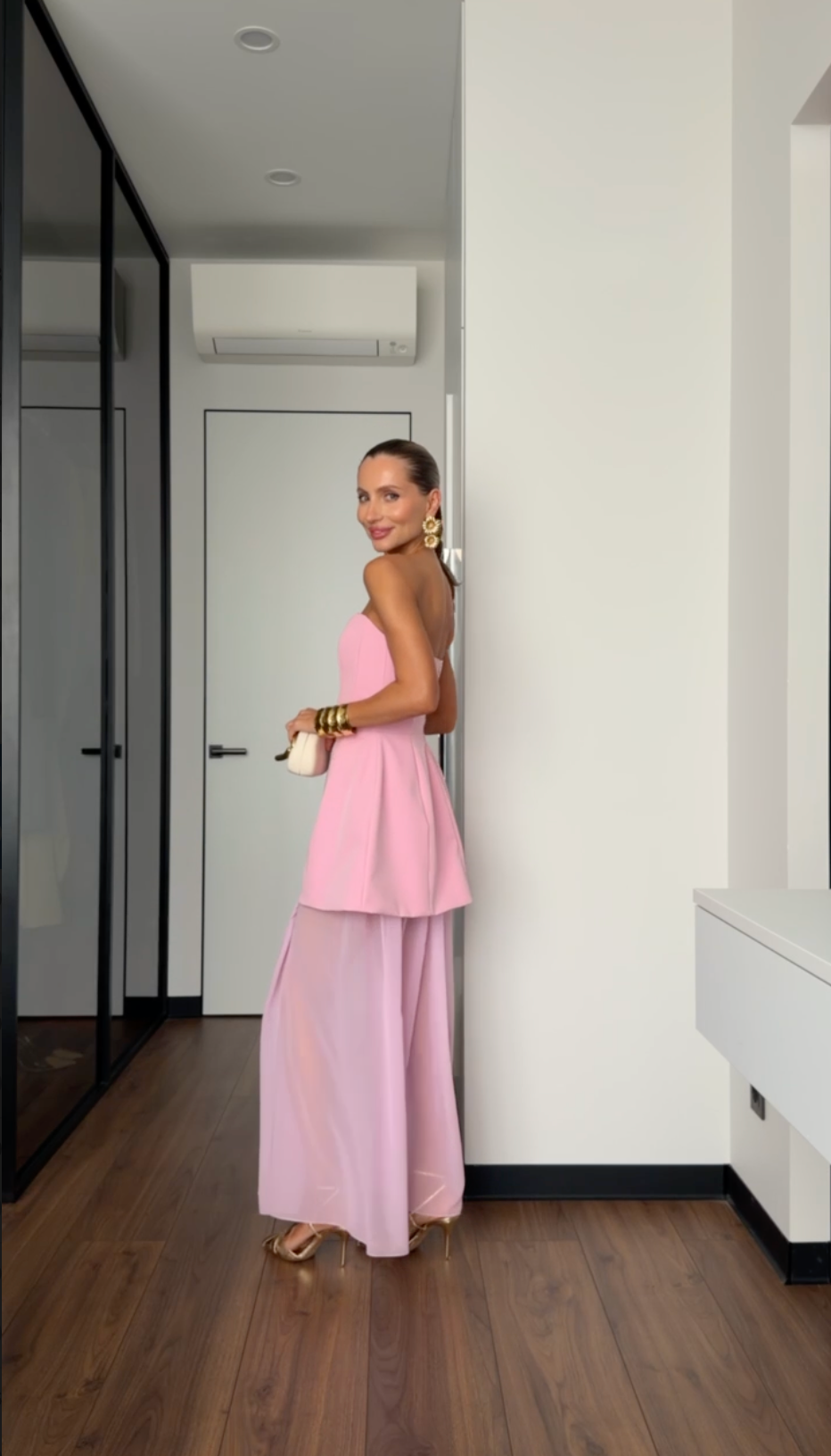 Woman in a pink dress standing in a modern interior setting