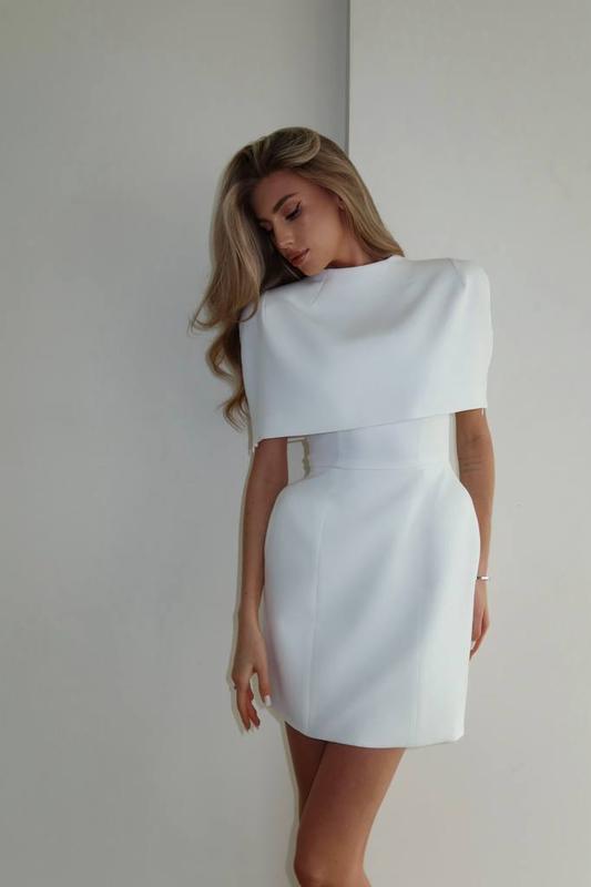 Woman wearing a white dress against a plain background