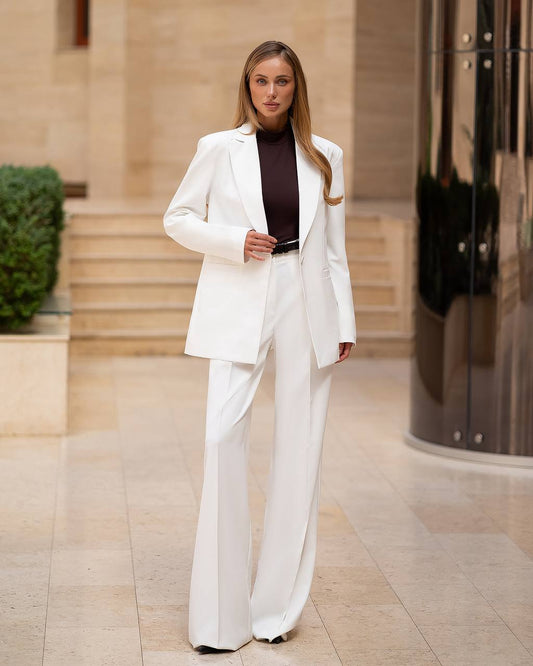 Woman in a white suit standing in an urban setting