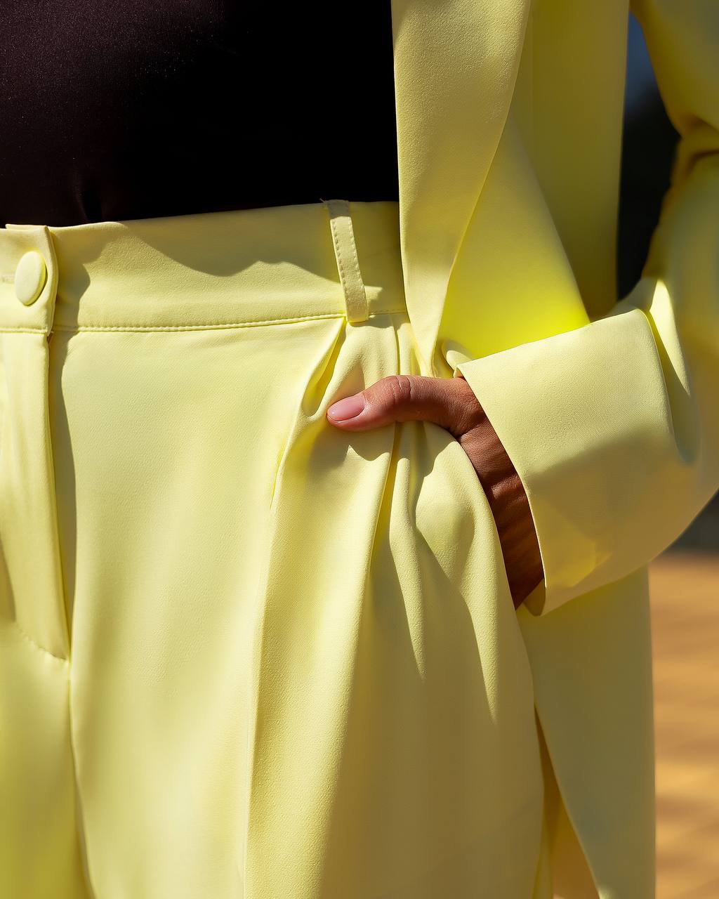 Close-up of a person wearing a light yellow coat with a blurred background