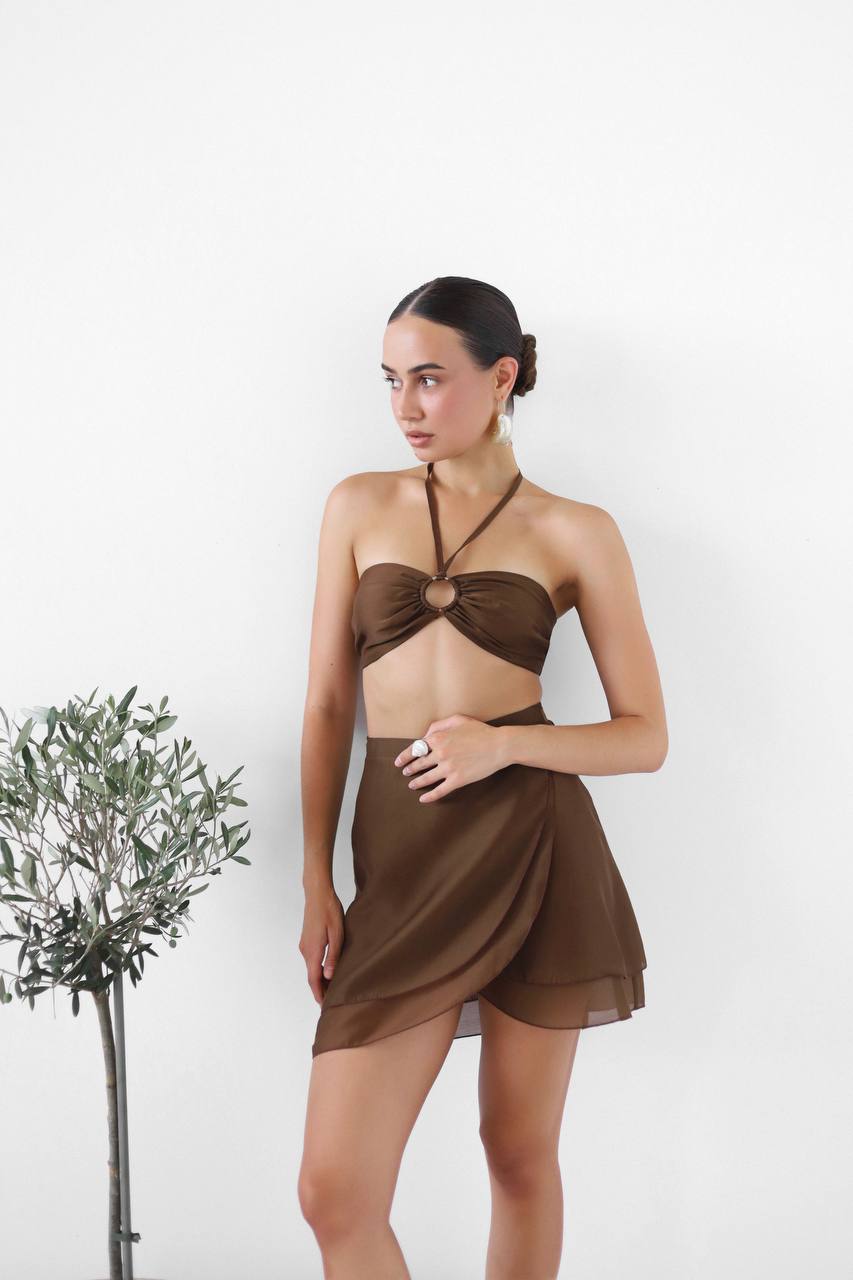 Woman wearing a brown halter top and skirt set on a white background