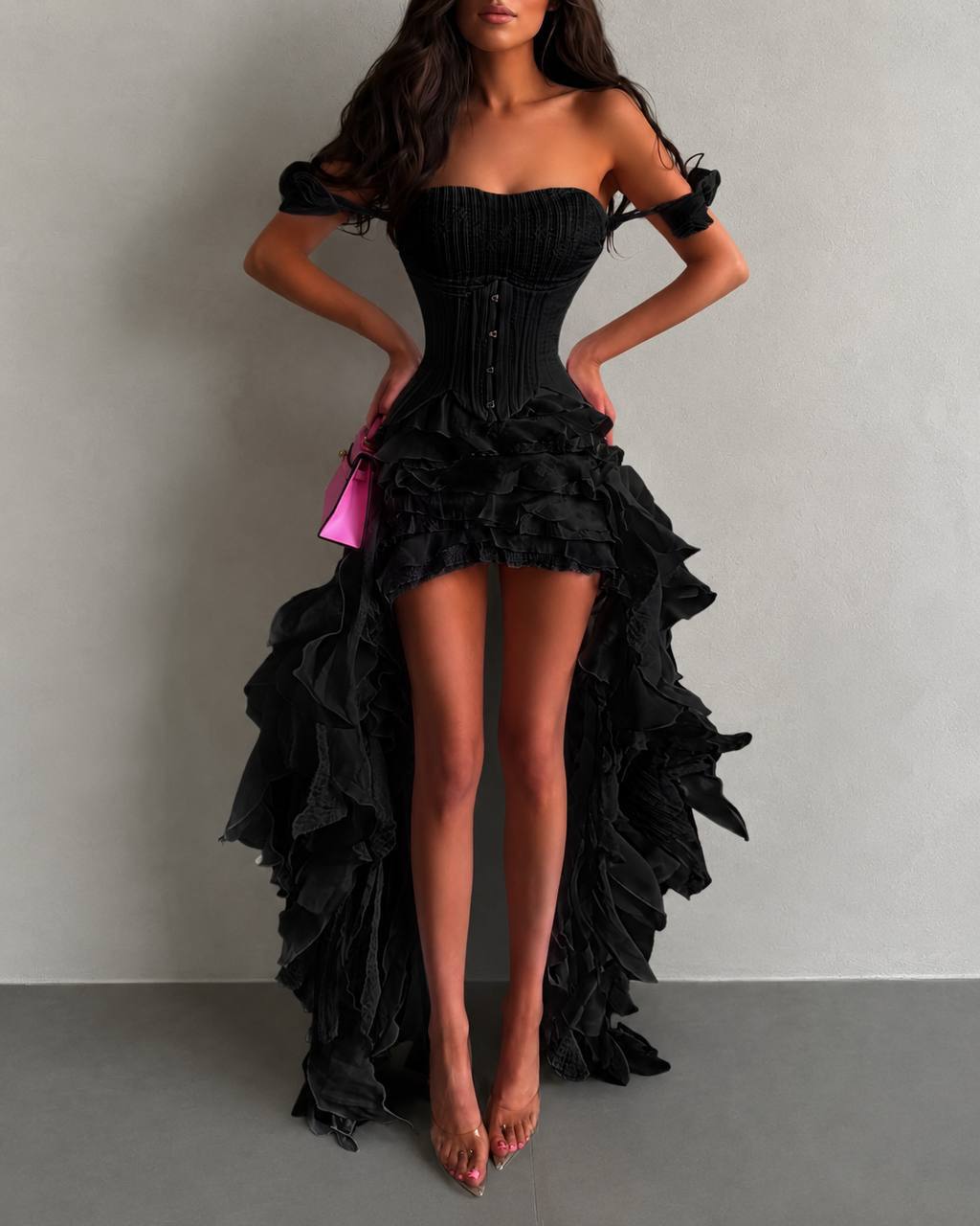 Black ruffled dress worn by a model on a plain background