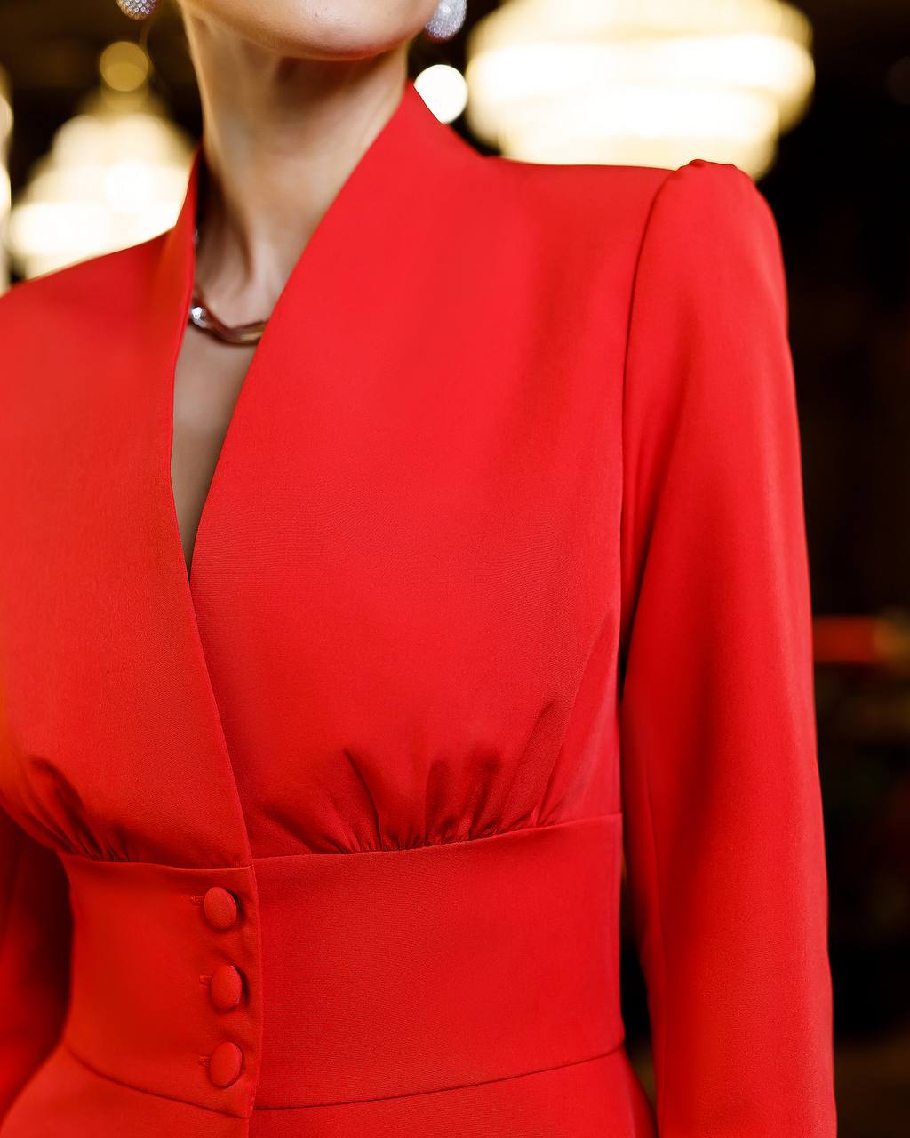 Red dress with long sleeves and buttons on a blurred background