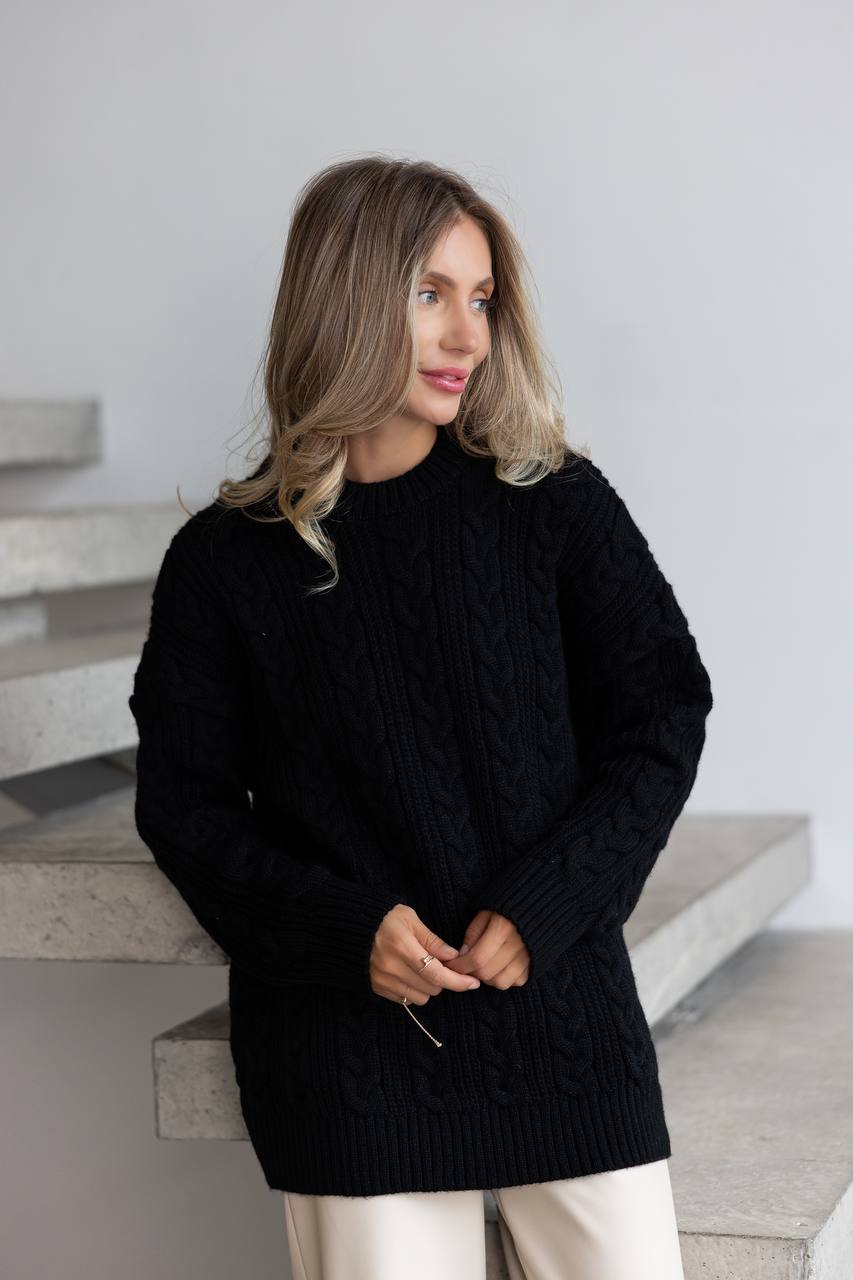 Woman wearing a black sweater standing on a staircase.